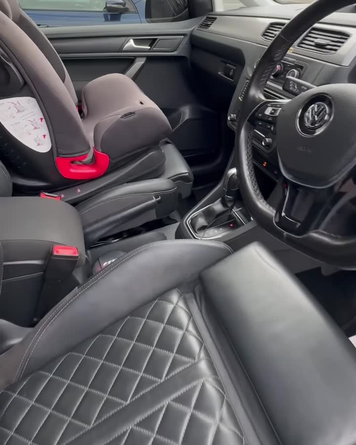 Clean quilted leather front seats and dashboard inside the VW Caddy