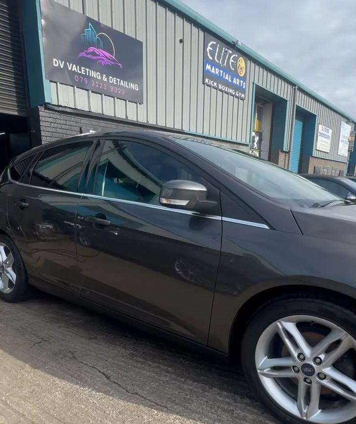Dark grey Ford Focus gleaming after a full valet and gloss enhancement, outside the unit